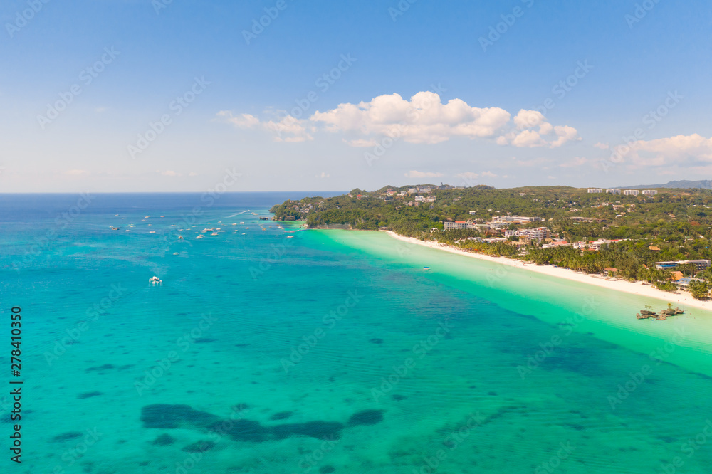 The coast of the island of Boracay. White beach and clear sea. Seascape with a beautiful coast in sunny weather. Residential neighborhoods and hotels on the island of Boracay, Philippines, view from