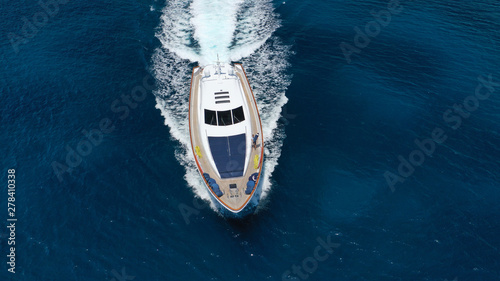 Zdjęcie lotnicze z drona do śledzenia luksusowego jachtu z drewnianym pokładem przelotowym w ciemnoniebieskich wodach wyspy Mykonos, Cyklady, Grecja