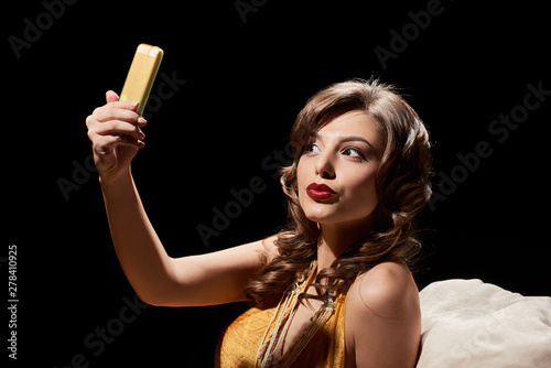 Attractive elegant woman with red lips making selfie on smartphone © Denys Kurbatov