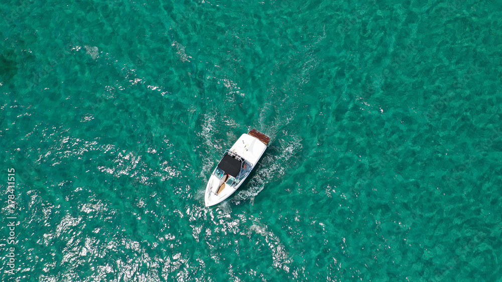 Aerial bird's eye view of inflatable rib boat cruising in high speed in turquoise clear water sea