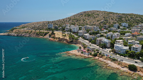 Aerial drone photo of famous seaside village of Varkiza with deep turquoise sandy beaches and clear blue sky, Athens riviera, Attica, Greece