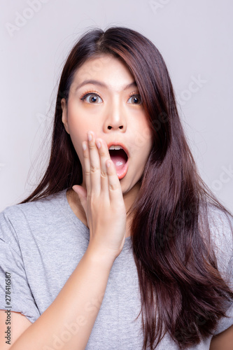Expression concept. Beautiful young asian woman gets surprising or shocking some product, brands or goods. Attractive beautiful young girl uses her hand close her mouth. She look at camera and say wow