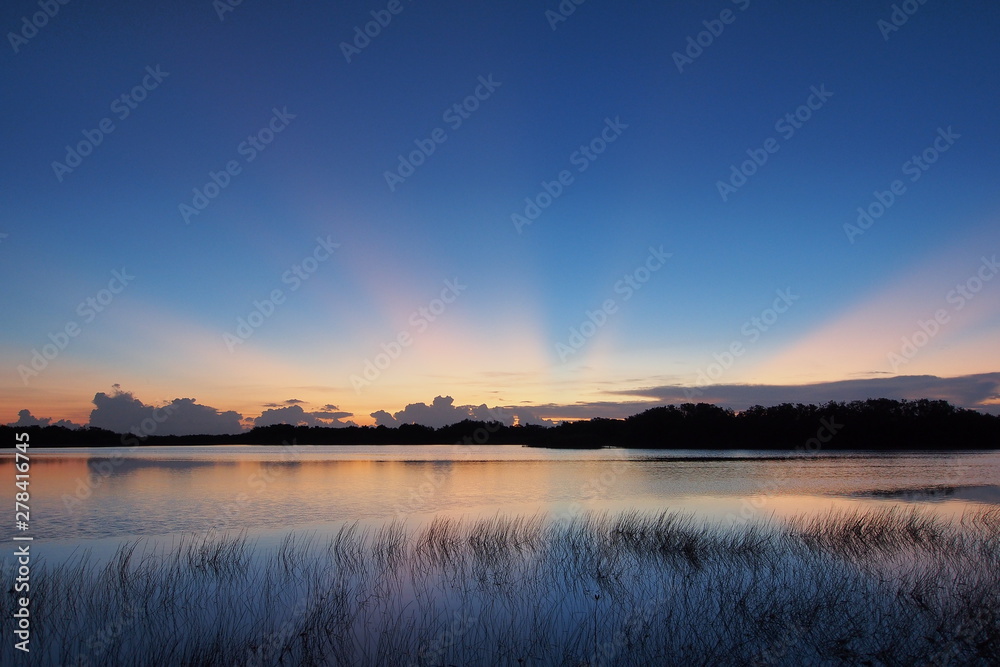 Sunrise with distinct sun rays over Nine Mile Pond in Everglades National Park, Florida.