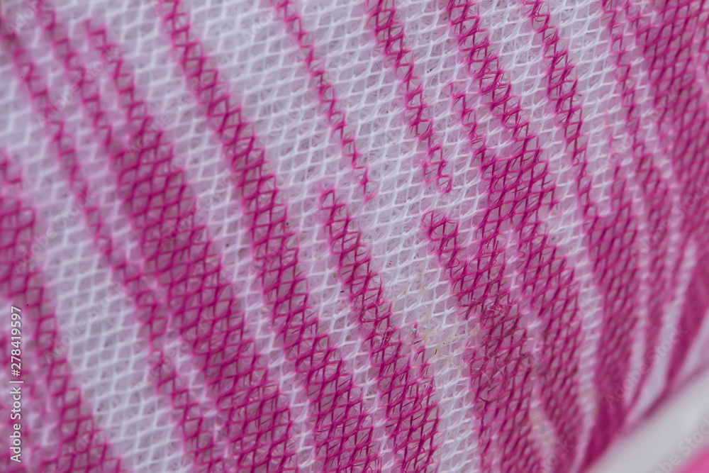 Fragment of pink sneaker fabric. The texture of the material of sports shoes