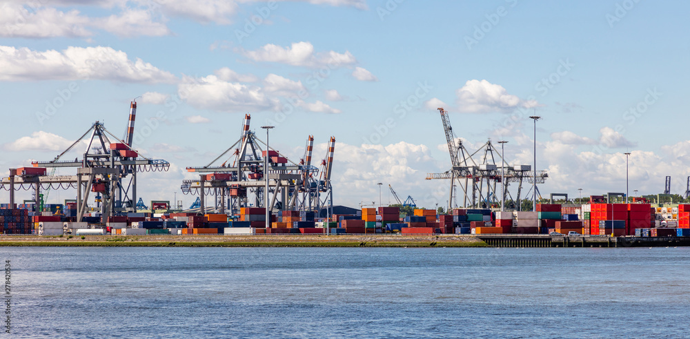 Naklejka premium Logistics business at harbor of Rotterdam, Netherlands. Cranes and cargo loading unloading