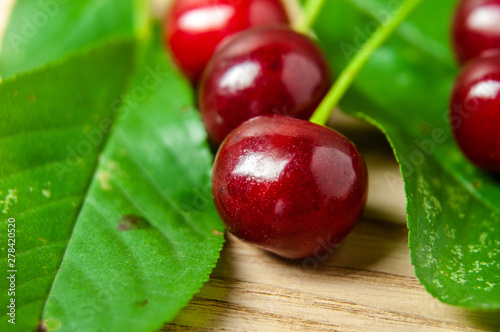 Tableau sur toile close-up of tart cherry fruits with green leaves