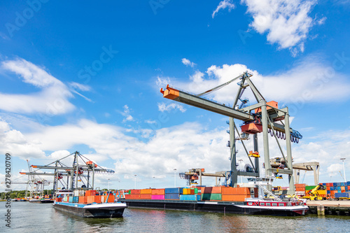 Container ship and logistics. Crane loading a container ship at Rotterdam port