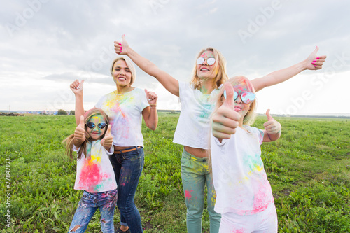Family, festival of holi and holidays concept - portrait of mothers and daughters covered in paint
