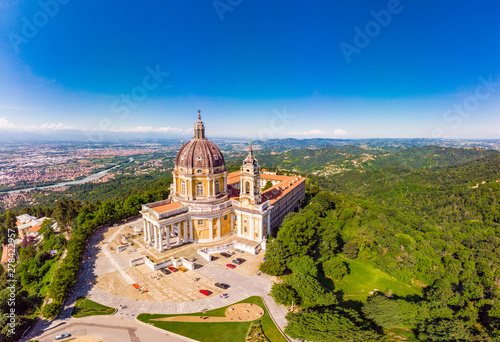 Beautifull aerial panoramic view to the famous from the drone Basilica of Superga in sunny summer day. The cathedral church located at the top of hill in italian Alps mountains. Turin, Piedmont, Italy photo