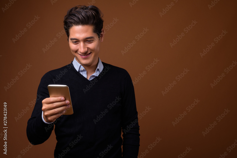 Young multi-ethnic handsome man against brown background Young multi-ethnic handsome man against brown background
