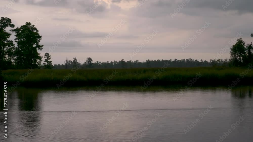 Sailing along a river at sunset Sailing along a river at sunset