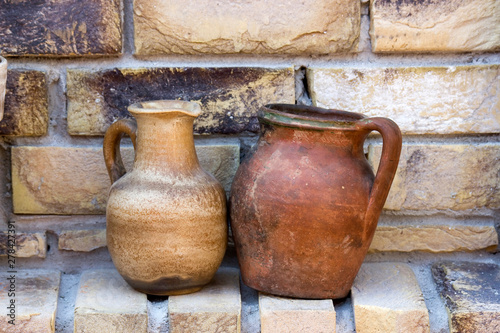 clay pots on a brick wall © Mira Drozdowski