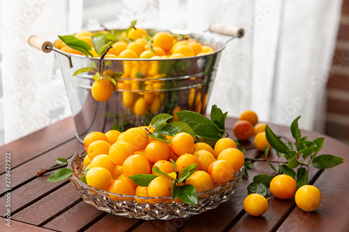 yellow plum Mirabel in a bowl after collecting on a wooden table . Summer fruit season.harvest.