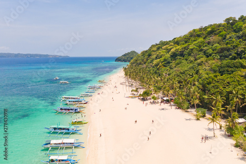 Puka Shell Beach, Boracay Island, Philippines, aerial view. Tropical white sand beach and beautiful lagoon. Tourist boats and people on the beach. People relax on the beautiful coast.