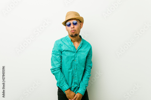 Young hispanic man wearing a summer clothes shrugs shoulders and open eyes confused. © Asier