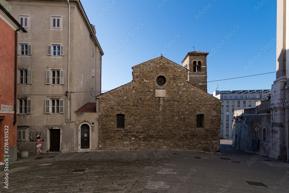 Photograph of the back facade of the Basilica of San Silvestro (Basilica di San Silvestro), where the street (via) of San Silvestro meets the (piazza) Piazza San Silvestro, Trieste, Italy