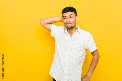 Fotografía Young hispanic man touching back of head, thinking and making a choice