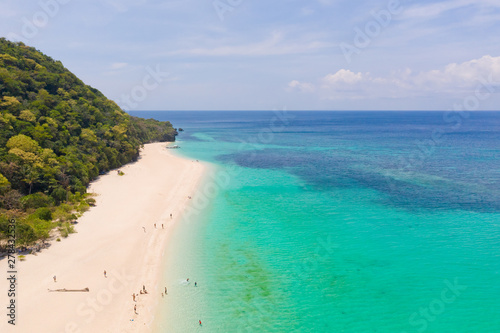 Puka Shell Beach. Wide tropical beach with white sand. Beautiful white beach and azure water on Boracay island, Philippines, top view. Tourists relax on the beach.