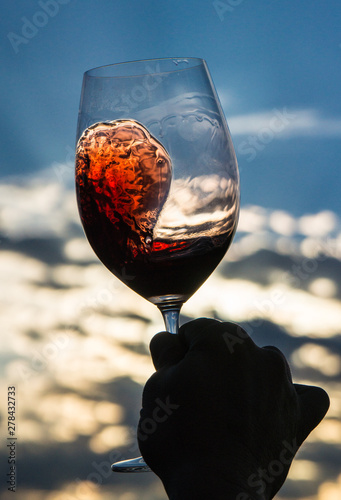 glass of red wine on a background of blue sky
