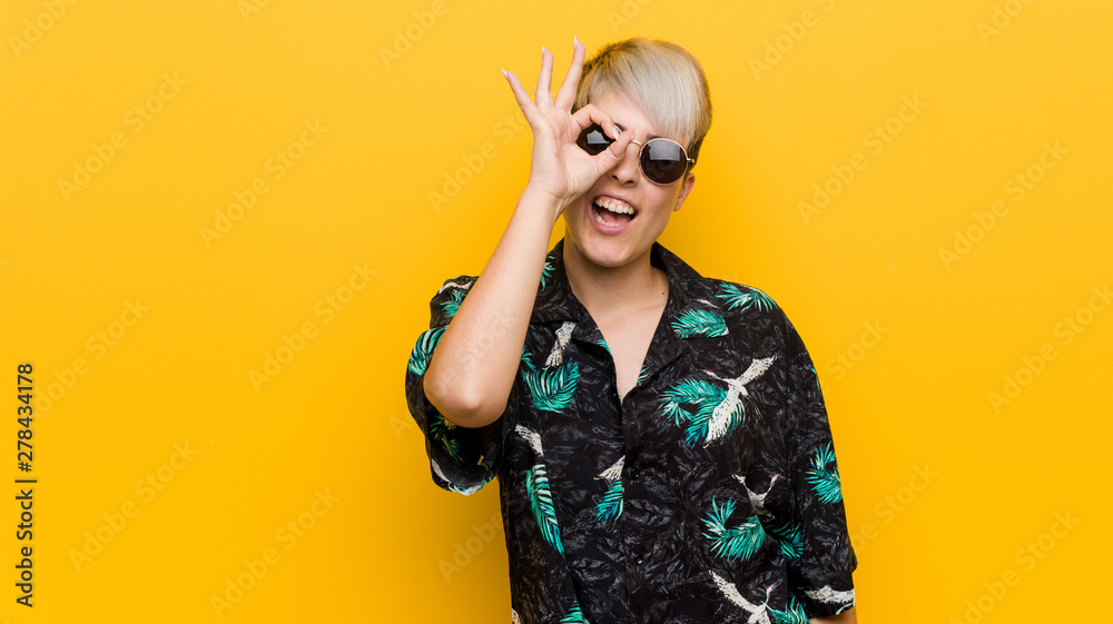 Young curvy woman wearing a summer look excited keeping ok gesture on eye. Young curvy woman wearing a summer look excited keeping ok gesture on eye.