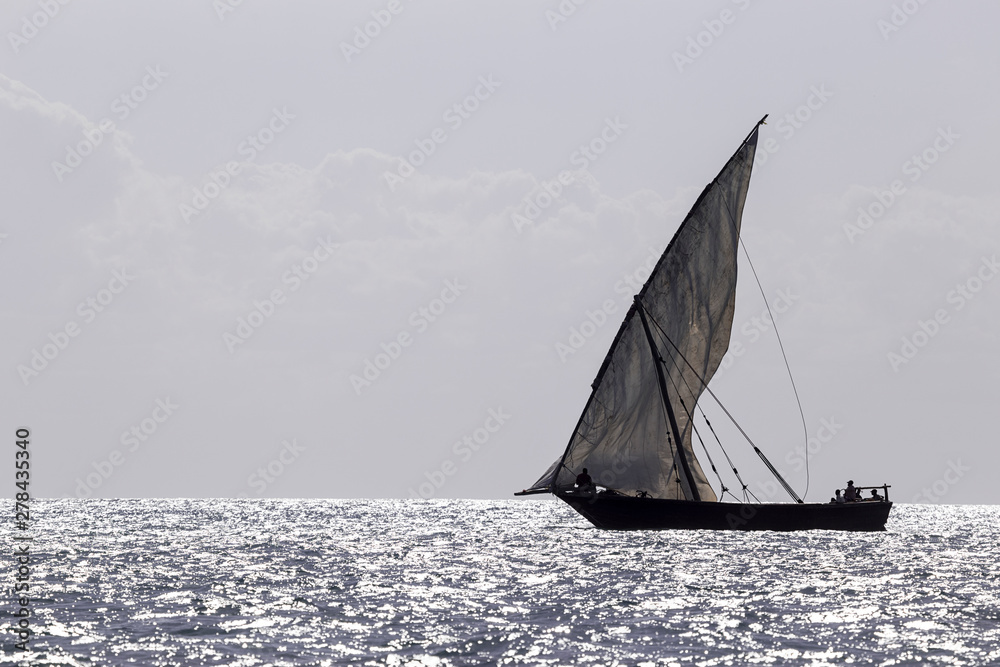 single dhow sailboat silhouetted