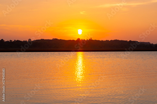 Sunset reflection lagoon. beautiful sunset behind the clouds and blue sky above the over lagoon landscape background. dramatic sky with cloud at sunset