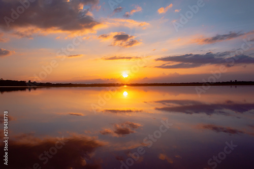 Fototapeta Naklejka Na Ścianę i Meble -  Sunset reflection lagoon. beautiful sunset behind the clouds and blue sky above the over lagoon landscape background. dramatic sky with cloud at sunset