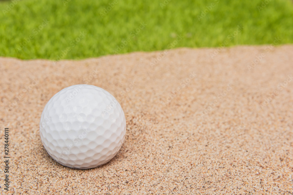 White golf ball in sand bunker on golf court. White golf ball in sand bunker on golf court.