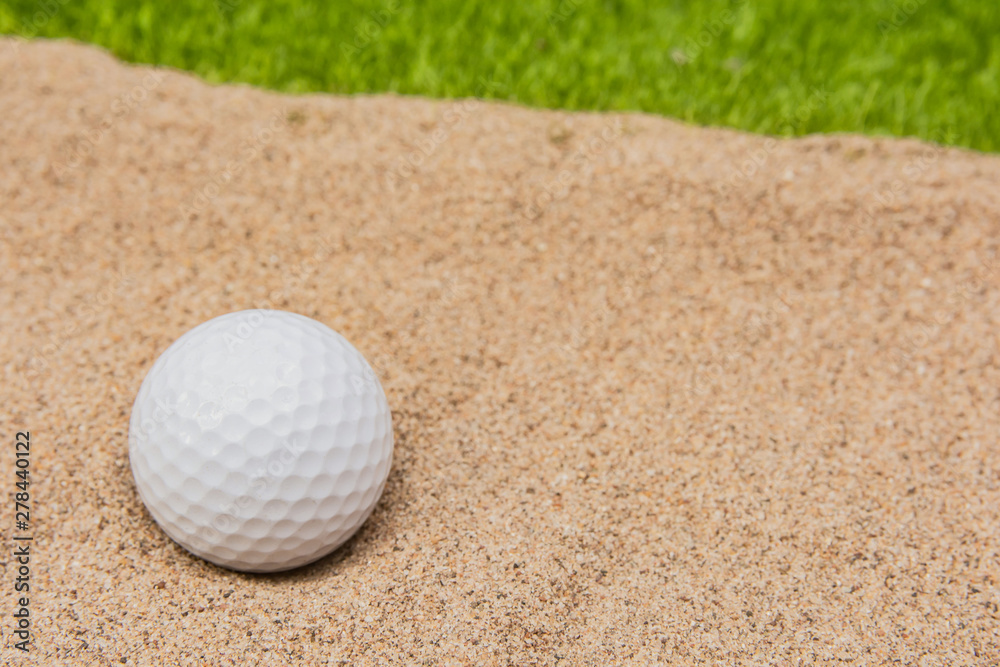 White golf ball in sand bunker on golf court. White golf ball in sand bunker on golf court.