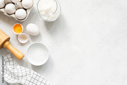 Baking Cooking Ingredients Flour Eggs Rolling Pin Butter And Kitchen Textile On Bright Grey Concrete Background. Top View Copy Space. Cookies Pie Or Cake Recipe Mockup