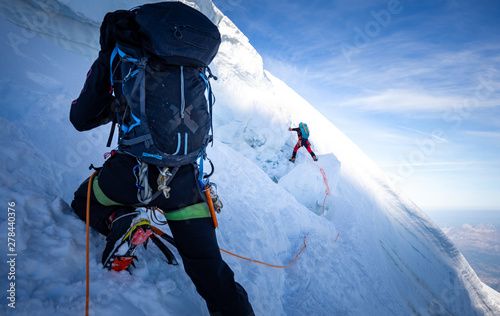 Two mountaineers climb steep glacier ice crevasse extreme sports, Mont Blanc du Tacul mountain, Chamonix France travel, Europe tourism. 