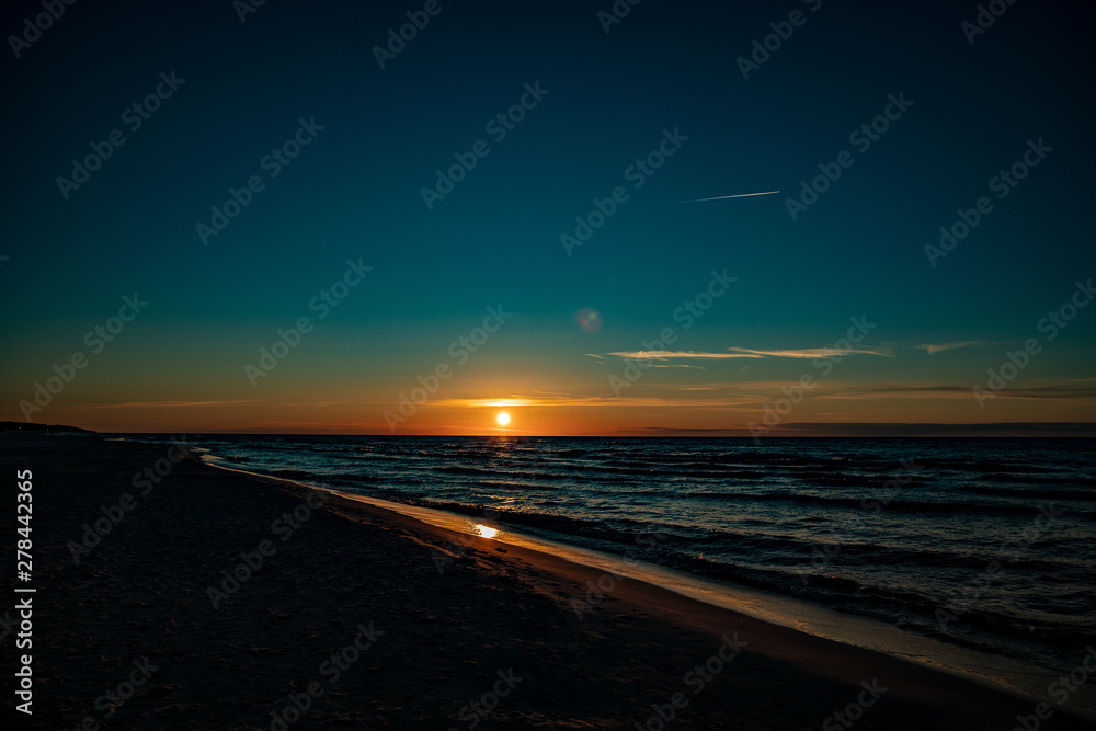  picturesque calm sunset with colorful clouds on the shores of the Baltic Sea in Poland