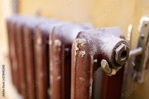 Heating cast-iron radiator  in apartment that is under construction, remodeling, renovation, overhaul, extension, restoration and reconstruction. Concept of home improvement.