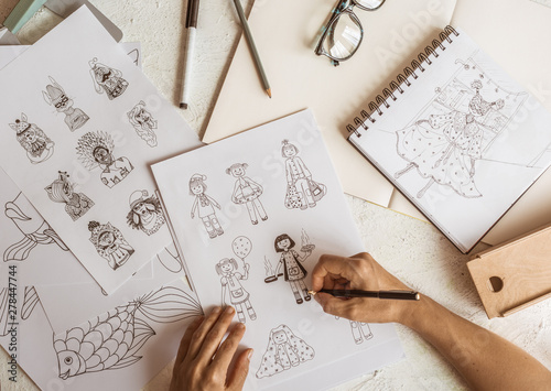 Animator designer draws sketches of various characters. Creating illustrations on paper for cartoons or video games.