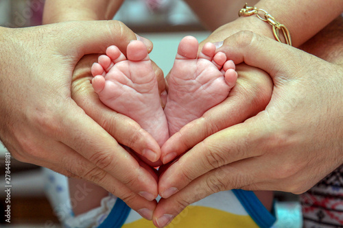 feet of a baby in his parents' hands