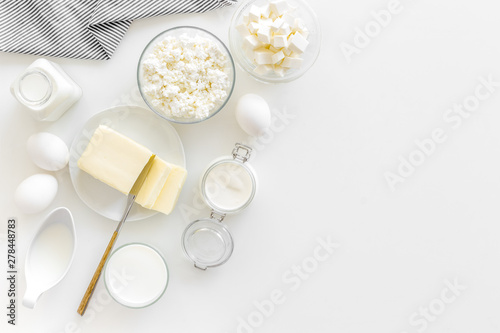 Fresh dairy products for breakfast with milk, cottage, eggs, butter, yougurt on white background top view mock up
