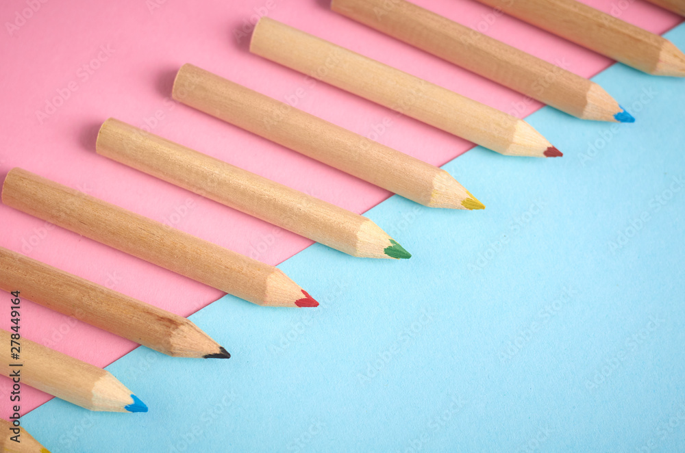 Wooden color pencils on blue background, flat lay Wooden color pencils on blue background, flat lay