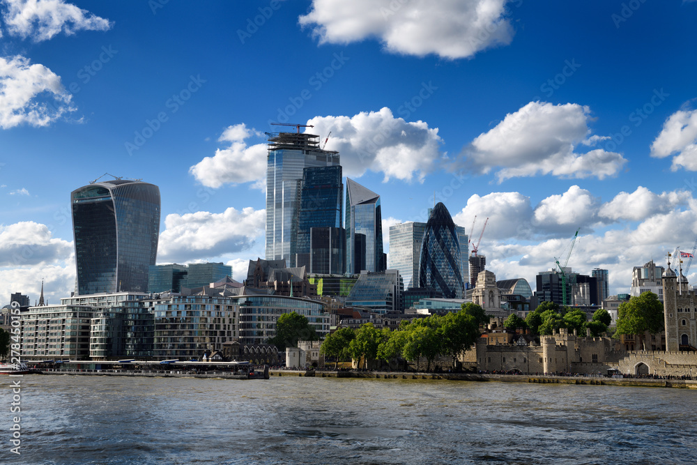 Tower Pier and Tower of London on the River Thames and financial district skyscrapers Walkie Talkie Cheesegrater Scalpel Gherkin London England