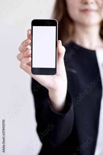 Business woman holding and showing a mobile phone.