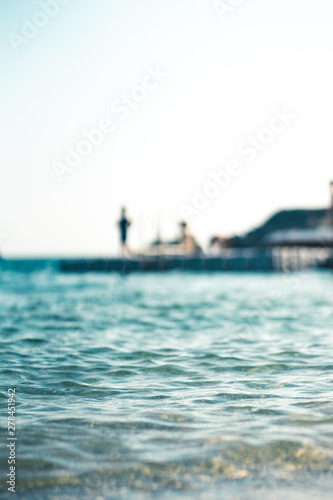 Floating platform in the sea, with teenagers having fun, out of focus © frederikloewer