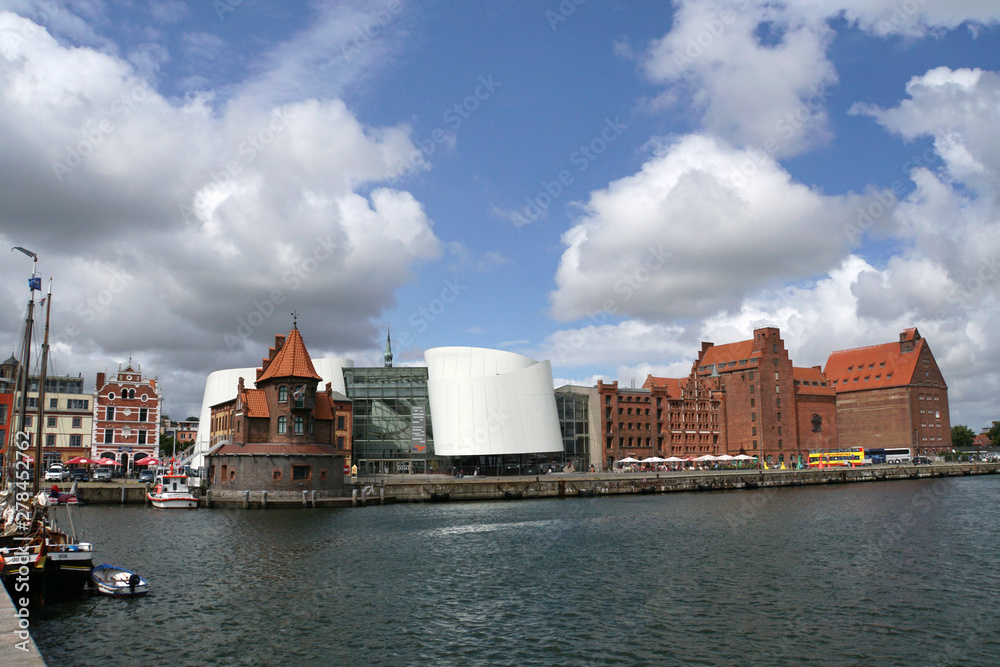 Naklejka premium Lotsenhaus am Hafen, dahinter Ozeaneum und Stapelhäuser