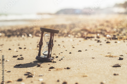 Hourglass on the beach, ocean. The concept of transience of time.