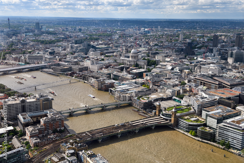 Fototapeta premium Aerial view of London England with BT Tower and bridges over the muddy River Thames and St Paul's Cathedral Anglican church