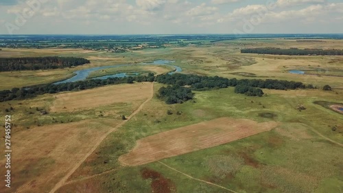 Flight on a kopter on boundless open spaces from below a field small river photo