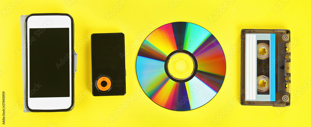 concept evolution music. Cassette, CD-disk, mp3 player, mobile phone.  Vintage, modernity. Banner. Photos | Adobe Stock