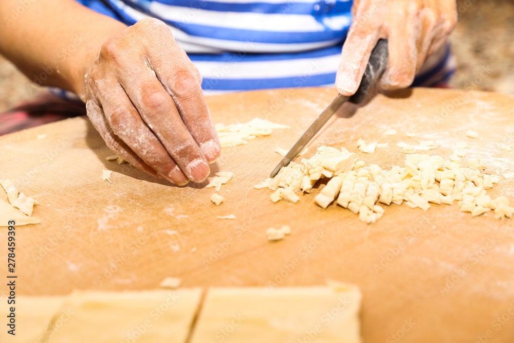 Side view woman's hands make Turkish Ravioli on table. Plates of traditional Turkish food. manti Side view woman's hands make Turkish Ravioli on table. Plates of traditional Turkish food. manti