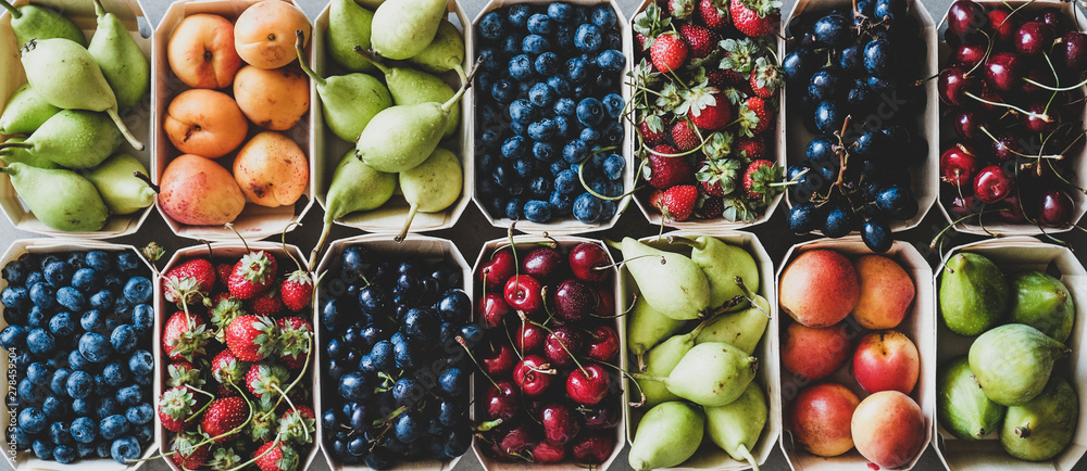 Naklejka Letnia odmiana owoców i jagód. Płaskie ułożenie dojrzałych truskawek, wiśni, winogron, jagód, gruszek, moreli, fig w drewnianych ekologicznych pudełkach na szarym tle, widok z góry