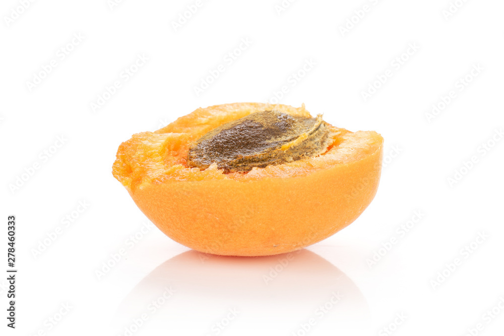 One half of fresh deep orange apricot with a stone isolated on white background