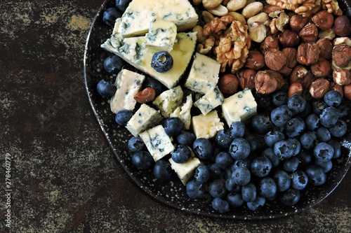 Cheese plate with blue cheese, nuts and blueberries. Healthy snack. Keto diet