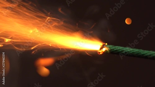 Close up macro shot of Burning fuse firecracker. Setting fire to wick of bomb photo